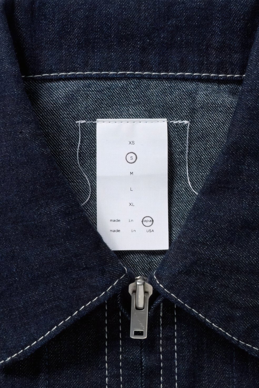 Dresen identity: woven size label inside a dark denim jacket