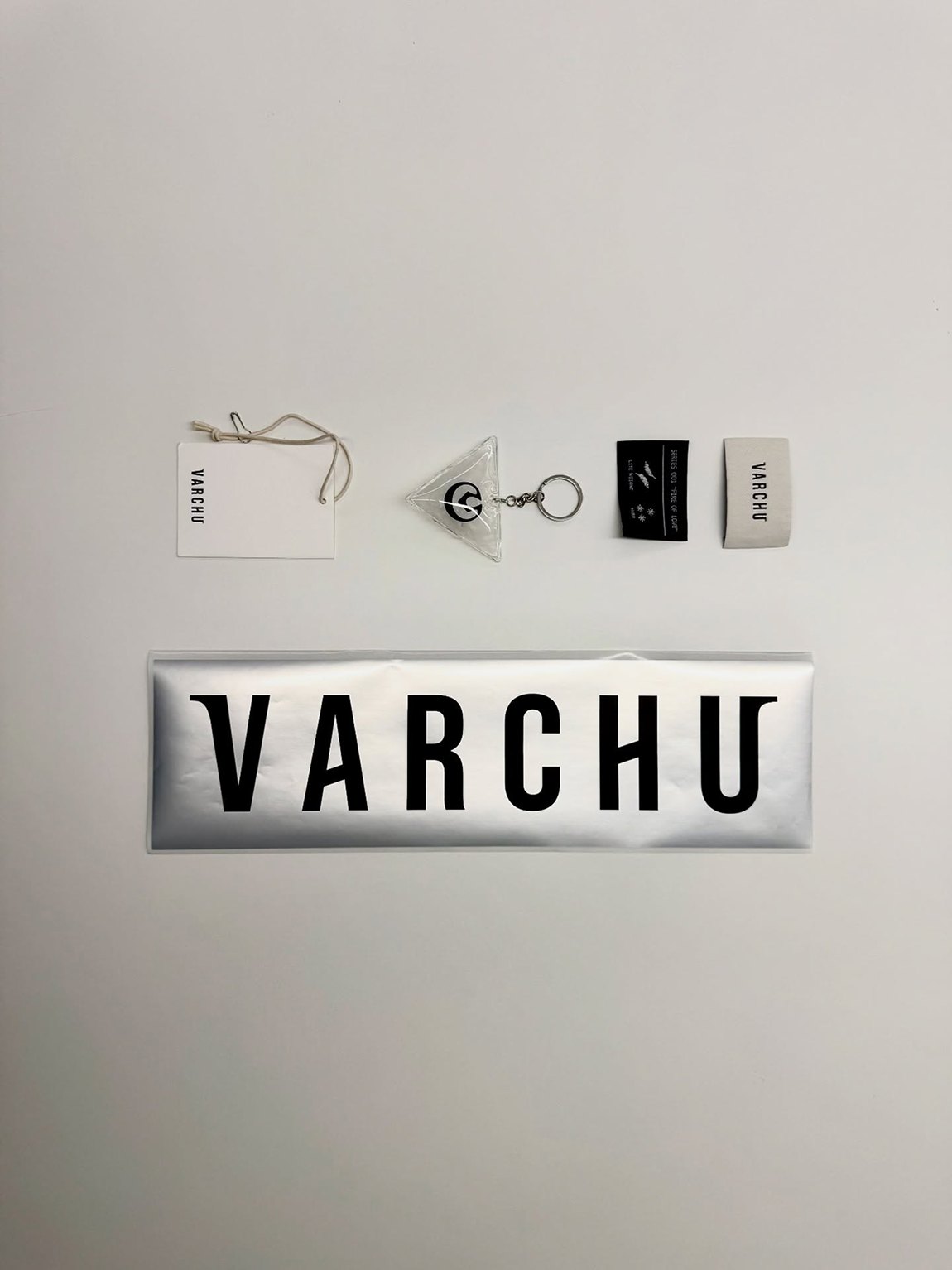 Varchu identity: hang tag, keyring, woven labels and a silver logotype sticker